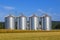 Four silver silos in corn field