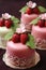 Four small cakes with strawberries on top of them