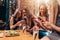 Four smiling female students sitting in cafeteria chatting using mobile phones