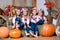 Four smiling girls twin sisters in Ukrainian wreaths sitting on haystacks. Autumn decor, harvest with pumpkins