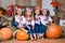 Four smiling girls twin sisters in Ukrainian wreaths sitting on haystacks. Autumn decor, harvest with pumpkins