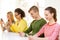 Four smiling students with smartphones at school