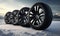 Four snow tires are shown in the snow