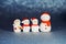 Four snowman figures on a shiny paper background