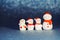 Four snowman figures on a shiny paper background. Christmas decorative smiling snowmen. Horizontal banner. Copy Space