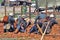 Four soldiers lay on the ground with guns.