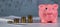 Four stacks of 10 roubles and pink piggy bank