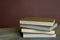 Four stamp albums books bunch on wooden table and bordeaux background.