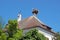 Four storks and a stork nest on the roof of an old house