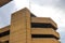 A four story brown concrete office buildings and blue sky with powerful clouds at Mud Island River Park