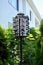 Four-story wooden white condo for birds. green foliage and white building facade on the background.