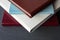 Four stylishly designed photobooks with leather covers, white, burgundy, brown and blue, of different thicknesses