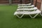 Four sunbeds on artificial grass in rainy weather