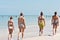 Four teen woman walking a tropical shoreline