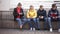 Four teenagers chatting on their smartphone on walking