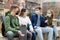 Four teenagers in protective masks are talking about play on walk on street