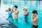 four teenagers in swimsuits at the pool wearing swimming goggles while preparing