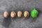 Four textured peeled walnuts and one green lie a line