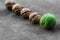 Four textured peeled walnuts and one green lie a line