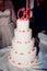 Four tiered wedding cake with white mastic and red beads