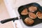 Four toasted steaks on a grilled pan, with finely chopped rosemary.