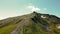 Four tourists with backpacks on their shoulders climb up in the summer. Aerial view from the back. Hiking in the