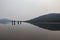 Four tourists are wading across the Jack London Lake at early foggy morning, Magadan region