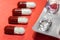 Four transparent capsule tablets with granules lie on a pink background next to an empty silver blister. Health and medicine.