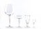 Four transparent elegant crystal glasses for cocktails lined next to each other on a white background