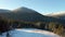 Four travelers pass by a large mountain. People conquer the snow-capped peaks of winter mountains. Aerial view.