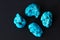 Four turquoise minerals on black background