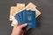 Four Ukrainian passports in men\'s hand, cash euros on background. Obtaining and exchanging foreign passport. Travel abroad