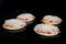 Four uncooked homemade mini pizzas on tray in electric oven, black background