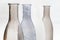 four vases for flowers of gray shades on a white background