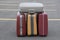 Four vintage suitcases on a parking lot