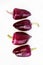 Four violet peppers on a white background. vertical