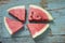 Four watermelon slices on grungy wood