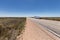 Four wheel drive vehicle and large caravan parked by the side of outback highway.