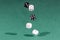 Four white and black dices falling on a green table
