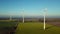 Four wind turbines rotating in agricultural landscape
