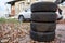 Four winter tire wheels ready for changing near car, copyspace