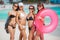 Four women in bikinis with lifeline near the ocean.