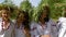 Four women in ethnic costumes walking outside on sunny day