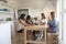 Four women at kitchen table with wine during girlsï¿½ night in