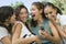 Four Women Laughing At Mobile Phone Display