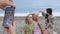 Four women taking pictures during a picnic on the beach