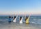 Four women were friends, sat back and raised their hands on the beach