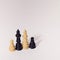 Four wooden chess figures king, queen and two pawns on a white background. Minimal.