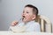 Four-year-old child in a white turtleneck eating pasta with a fork at the table