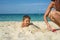 Four year old toddler boy playing with beach toys with mother on